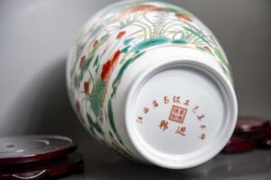 Hand-painted Jingdezhen porcelain vase with birds and blossoms on mahogany stand